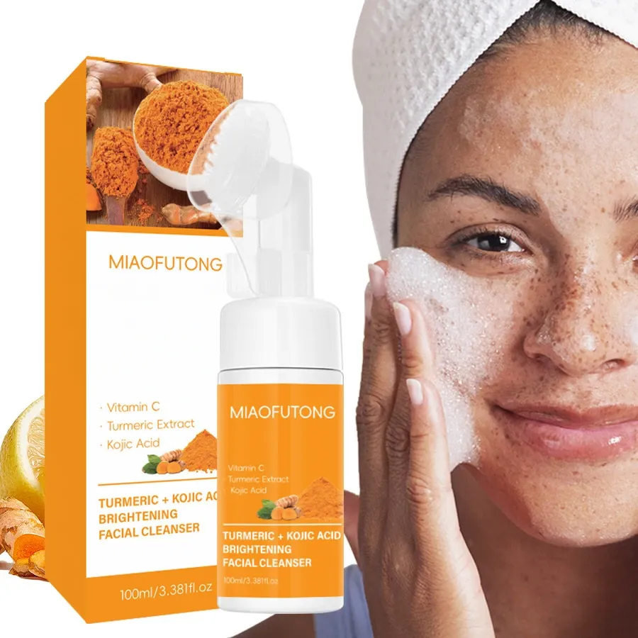 Orange and white MIAOFUTONG Turmeric + Kojic Acid Brightening Facial Cleanser bottle and box, with integrated silicone facial brush, vitamin C and turmeric extract callouts, shown on a clean white background with a partially visible model holding her face.